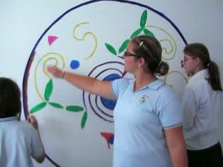 Ni�as pintando un mural enla pared