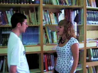 Chico y chica charlando de pi� en biblioteca