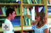 Chico y chica charlando de pi� en biblioteca